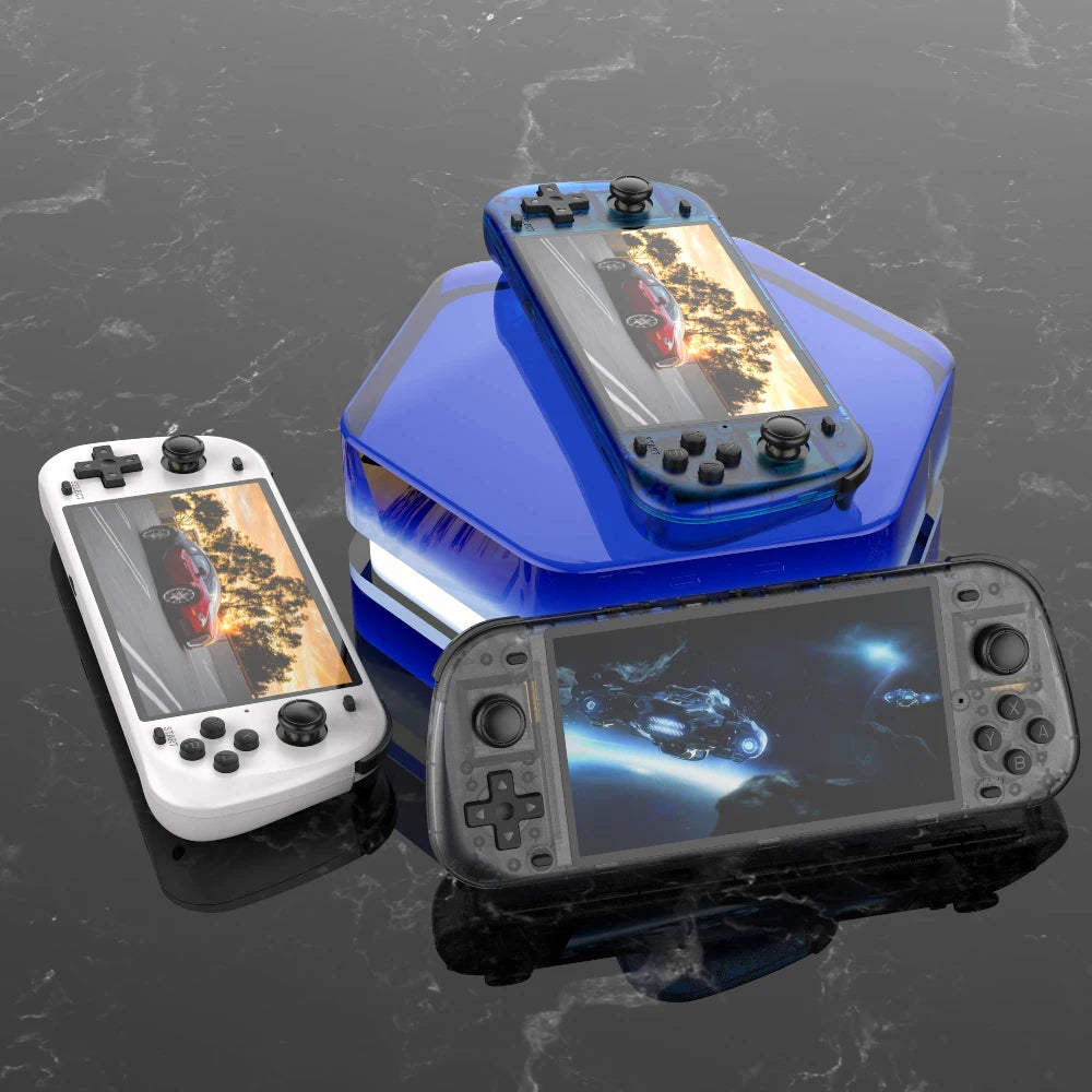 Three handheld gaming consoles on a reflective black surface