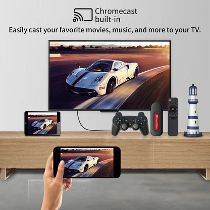 Smart TV displaying a car on screen with a smartphone, gaming controller, and remote control on a wooden stand.